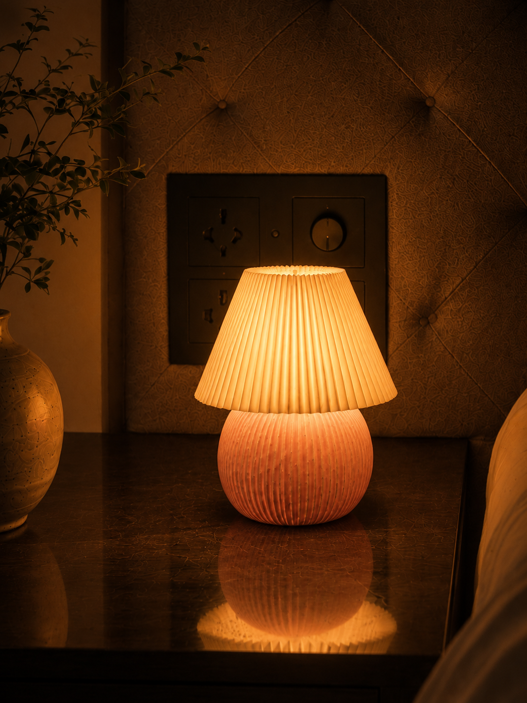 Berry Glow table lamp glowing warm white light on a nightstand
